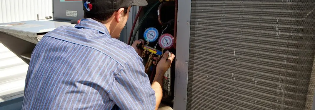 HVAC technician servicing a condenser unit in Saratoga