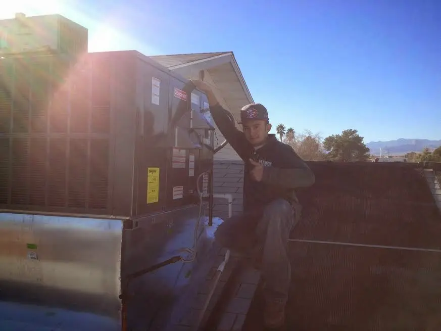 HVAC technician performing AC Tune-Up on a rooftop unit in Saratoga